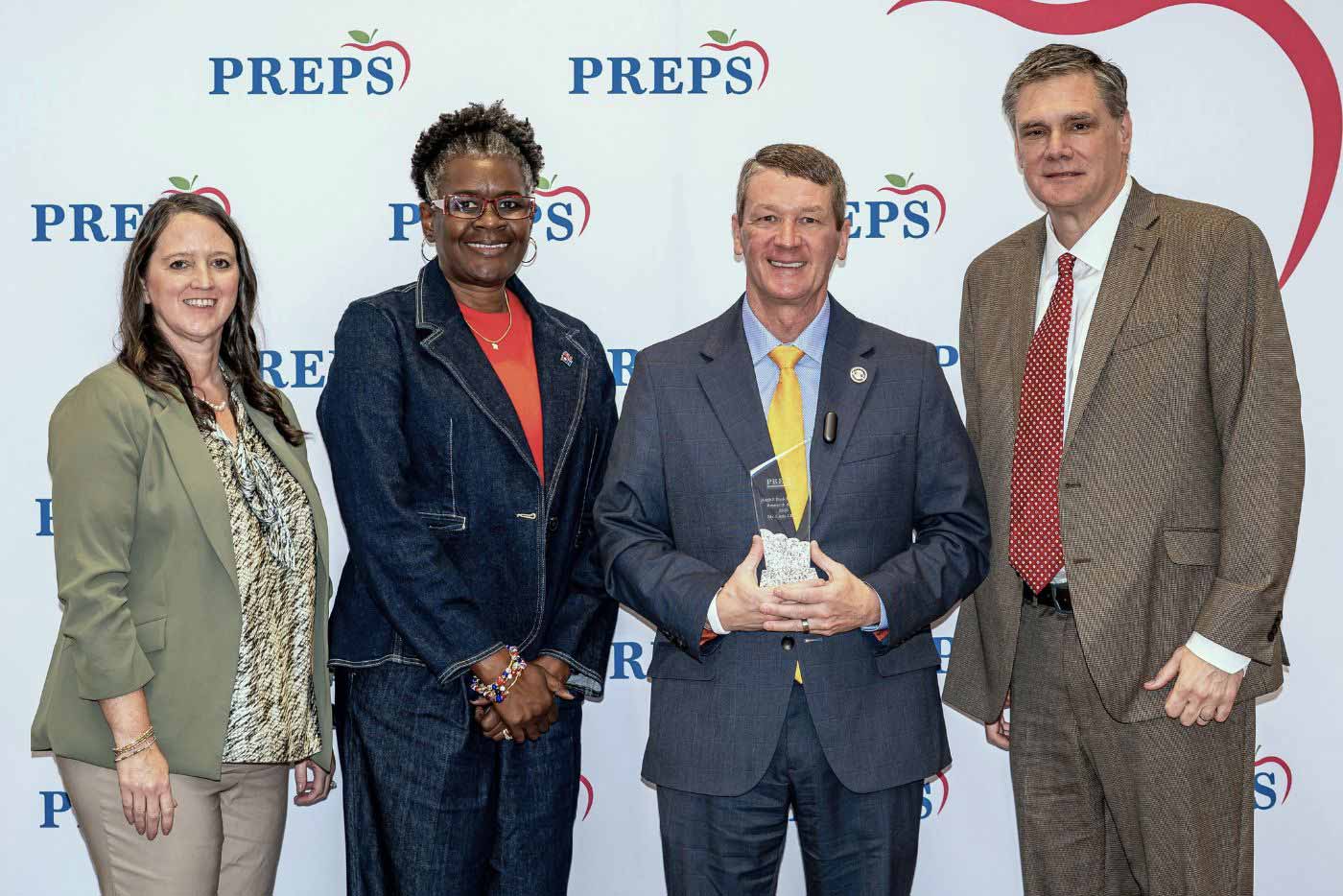 Chris Chism receiving the 2026 Hugh I. Peck Research Award at the PREPS Conference, congratulated by PREPS board members